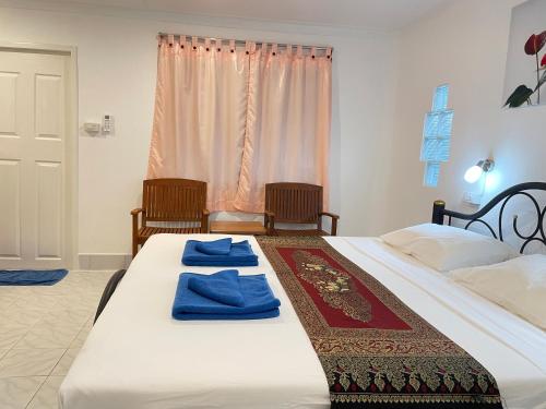 1 dormitorio con 2 camas y toallas azules. en Lanta Island Resort - SHA Extra Plus, en Ko Lanta