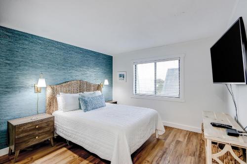 a bedroom with a bed and a flat screen tv at Oceanside 308-B in Isle of Palms