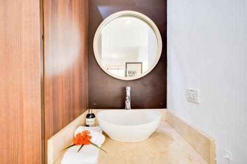 ein Badezimmer mit einem weißen Waschbecken und einem Spiegel in der Unterkunft Club Voca #9 in Coco