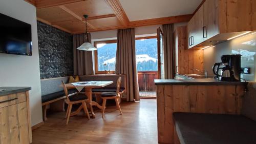 cocina con mesa y sillas en una habitación en Appartement Moaeben, en Alpbach