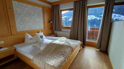 1 dormitorio con 1 cama y 2 ventanas grandes en Appartement Moaeben, en Alpbach