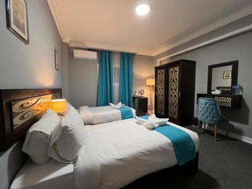 um quarto de hotel com duas camas e uma cadeira em Pyramids Gate Hotel no Cairo