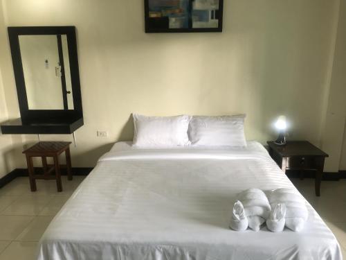 um quarto com uma grande cama branca com duas toalhas em Parisia House em Khao Lak