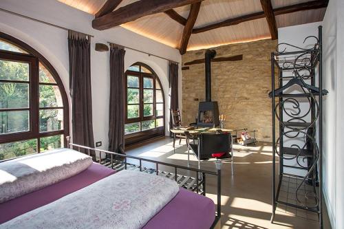 a bedroom with a bed in a room with windows at Cascina IL SOGNO in Cossano Belbo