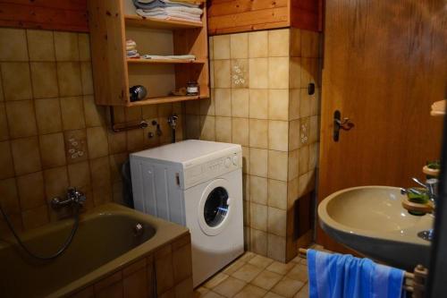 a bathroom with a washing machine and a sink at Haus Brugger in Rennweg