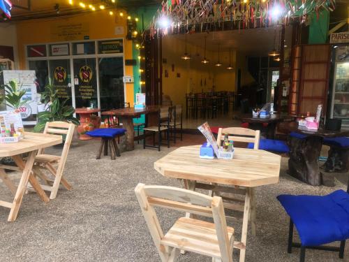 - un groupe de tables et de chaises en bois dans un restaurant dans l'établissement Parisia House, à Khao Lak