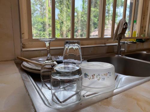 a kitchen sink with glasses and dishes on it at Green Haven in Mbale
