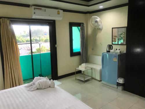 a bedroom with a bed and a bathroom with a window at Parisia House in Khao Lak