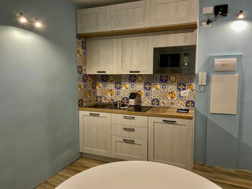 a kitchen with white cabinets and a white table at Sendy Home Roccaraso 2 in Roccaraso