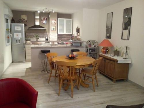 une cuisine avec une table et des chaises en bois dans l'établissement Superbe appartement lumineux au sud d Orange, à Orange