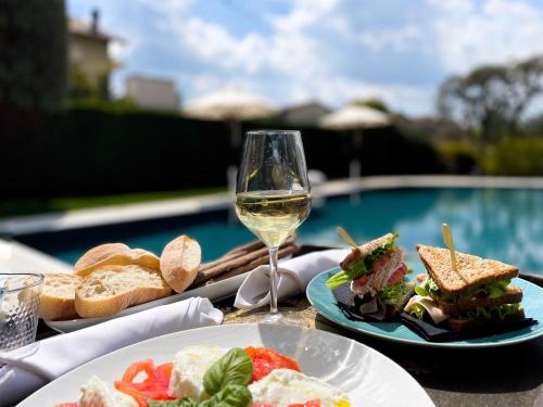 una mesa con dos platos de comida y una copa de vino en Corte Gondina Boutique Hotel, en La Morra