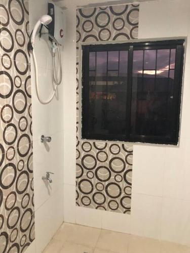 a bathroom with a shower with a window and a window at Luzville Residences - C8 in Naic