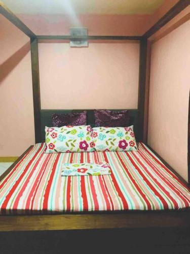 a bed with a wooden headboard and pillows on it at Luzville Residences - C8 in Naic