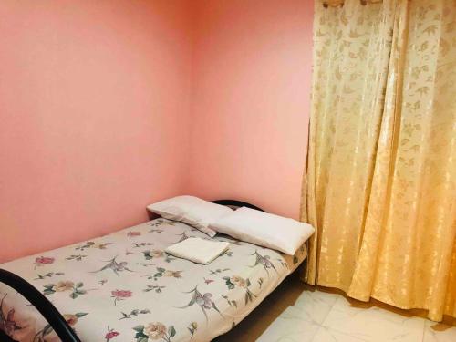 a small bedroom with a bed and a yellow curtain at Luzville Residences - C8 in Naic