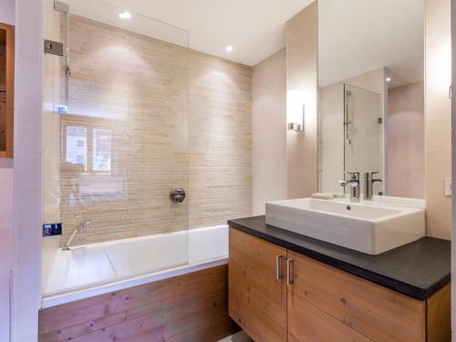 ein Badezimmer mit einem weißen Waschbecken und einer Badewanne in der Unterkunft Magnifique Appartement au Centre de Val-d'Isère, Proche Pistes et Commerces - FR-1-519-1 in Val dʼIsère