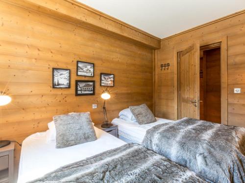 zwei Betten in einem Zimmer mit Holzwänden in der Unterkunft Magnifique Appartement au Centre de Val-d'Isère, Proche Pistes et Commerces - FR-1-519-1 in Val dʼIsère