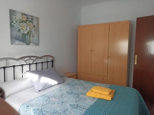 een slaapkamer met een bed met een gele handdoek erop bij Casa Ana in Algodonales
