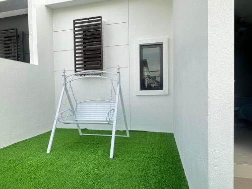 a chair sitting on a green floor in a room at 《Untitled HomeStay》Sitiawan in Sitiawan