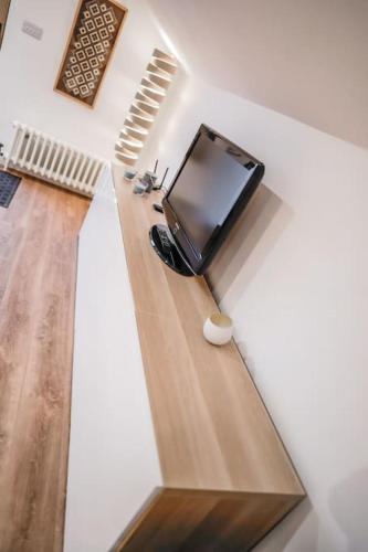 a living room with a flat screen tv on a wall at The Loft Apartment @ Lower Coombe Royal in Kingsbridge