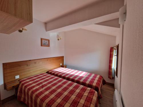 オルシエールにあるAppartement au Chalet d'Orcières Merletteの小さなベッドルーム(ストライプ毛布付きのベッド付)