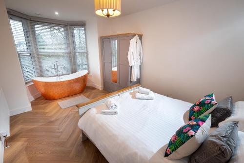 a bathroom with a large bed and a bath tub at Luxury Pet-Friendly 2 Bed Retreat in Central Bowness with Copper Roll-Top Bath & Sun Terrace in Bowness-on-Windermere
