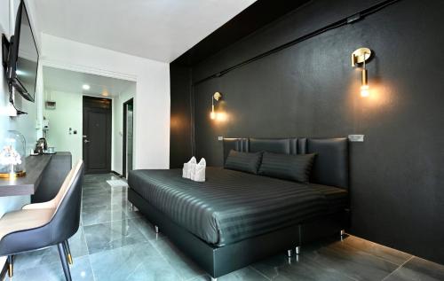 a bedroom with a bed with a black wall at Pangtip in Lampang