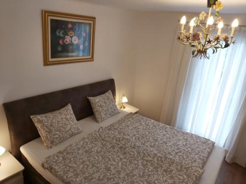1 dormitorio con cama y lámpara de araña en Ferienhaus Eisenberg, en Vaskeresztes