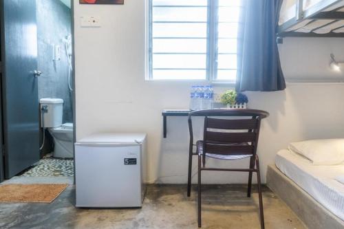 a small kitchen with a table and a chair in a room at Durian Ecolodge in Tampin