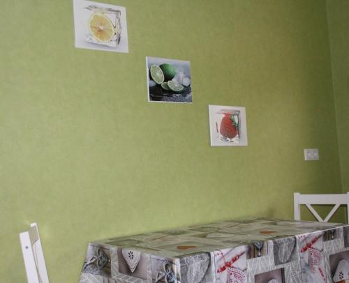 a bedroom with green walls with pictures on the wall at Ferienwohnung Felicitas Wilthen in Wilthen