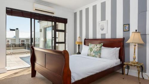 1 dormitorio con cama y ventana grande en Harbour Close Boutique Villa en Ciudad del Cabo