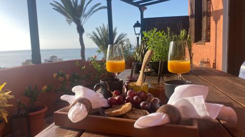 聖地亞哥海灘的住宿－Casa Moni Ferienwohnung mit Meerblick，一张桌子,上面放着一盘食物和两杯橙汁