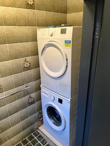 a washer and dryer in a corner of a bathroom at Glencree Air in Kilmeaden