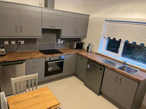 a kitchen with stainless steel appliances and a wooden table at Glencree Air in Kilmeaden