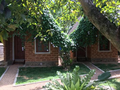 a brick house with a tree in front of it at Sky View Cabin Unawatuna in Unawatuna