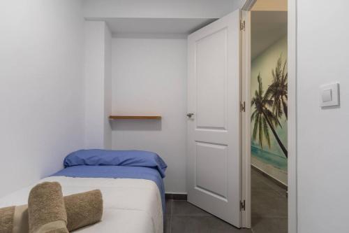 a small bedroom with a bed and a door at Apartamento cerca del mar, del puerto y del centro in Valencia