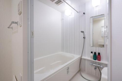 a white bathroom with a shower and a bath tub at Fuchsia - Vacation STAY 20104v in Nagoya