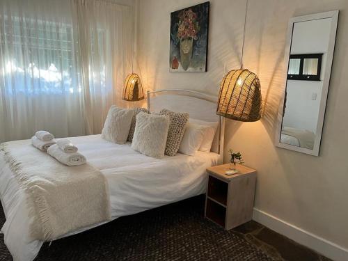 a bedroom with a white bed with towels on it at ENCHANTING SELF-CATERING VILLA with QUEEN BED AT BOKMAKIERIE VILLAS in Windhoek