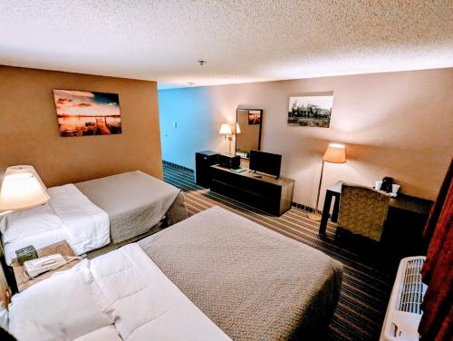 una camera d'albergo con due letti e una televisione di Woodfield Inn and Suites a Marshfield