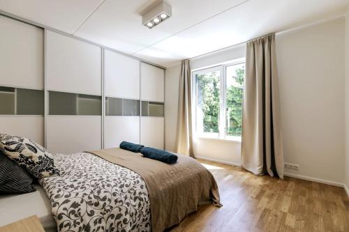 a bedroom with a bed and a large window at Tallinn Residences in Petrikyula