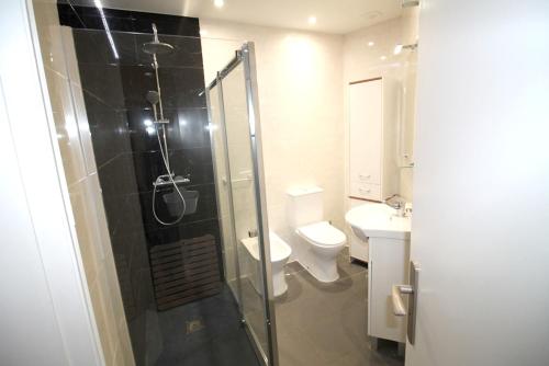 a bathroom with a shower and a toilet and a sink at Charming apartment in Portimão – 45 m² with a shared pool in Portimão