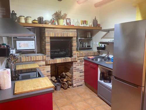 uma cozinha com uma lareira de tijolos em Cals Piris Casa Rural em Cabacés