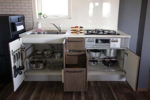 a kitchen with a sink and a stove at Yadoya YADOKARI in Pippu