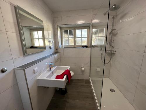 een witte badkamer met een wastafel en een douche bij FeWo Lotti in Berchtesgaden