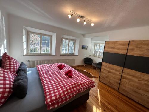 um quarto com uma cama com um cobertor xadrez vermelho em FeWo Lotti em Berchtesgaden