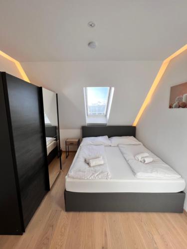 um pequeno quarto com uma cama e uma janela em modern flat vienna with two rooms em Viena