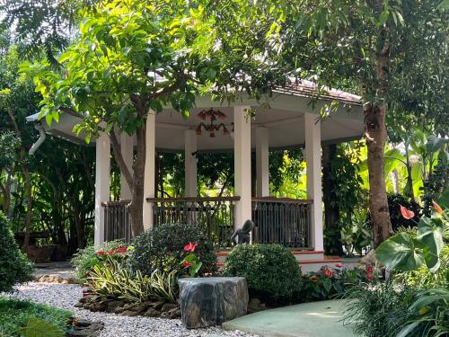 a gazebo in a garden with flowers and plants at Home of Dusita in Lamphun