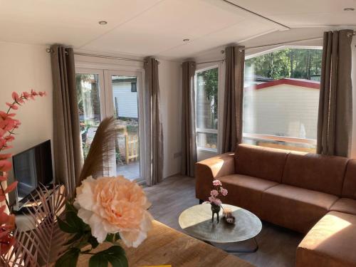 a living room with a couch and a table at Chalet Toetje op de Veluwe in Hoenderloo