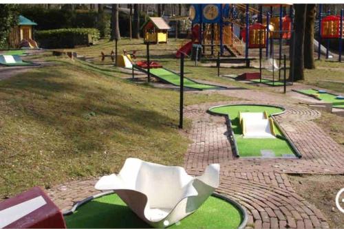 a playground with a white chair in a park at Chalet Toetje op de Veluwe in Hoenderloo