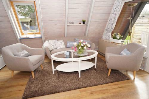 een woonkamer met een bank, 2 stoelen en een tafel bij Zeltdachhaus _ Renovierung 2019 _ in Damp