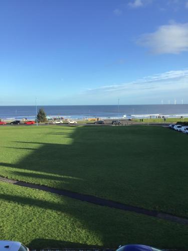 a large grass field with the ocean in the background at Sea View Guest House in Hartlepool